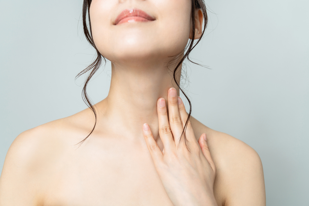 Close up of a woman lifting up her head and stretching out her neck to show off her chin after getting dermal fillers. Close up of a woman lifting up her head and stretching out her neck to show off her chin after getting dermal fillers.