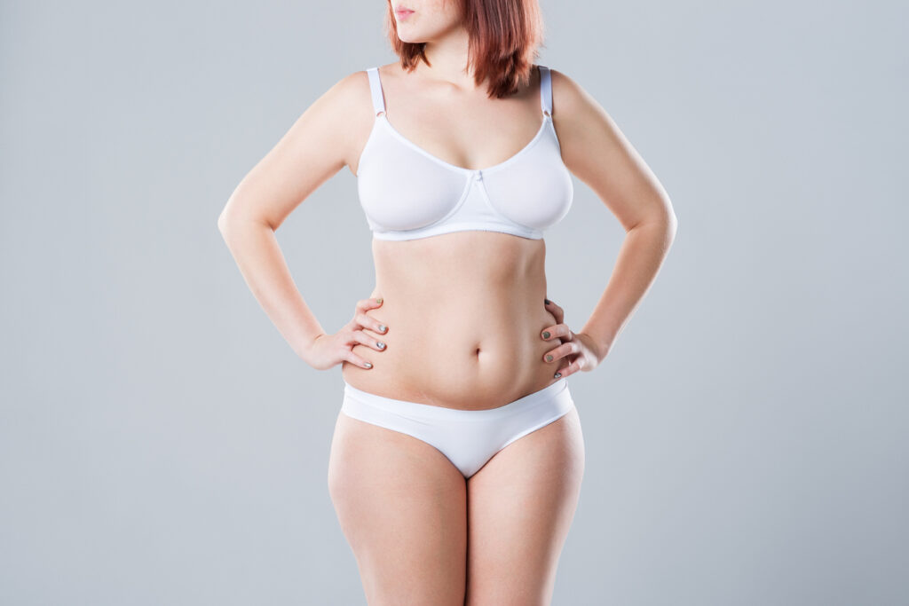 Fit young woman with a little bit of excess weight in the stomach, possibly a good candidate for tummy tuck. Fit young woman with a little bit of excess weight in the stomach, possibly a good candidate for tummy tuck.