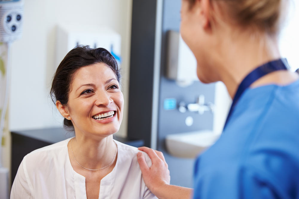 Woman meeting with medical professional to discuss surgery details Woman meeting with medical professional to discuss surgery details