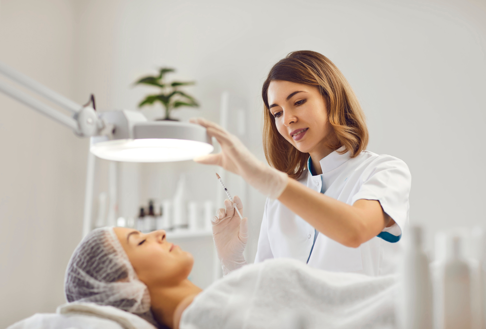 Aesthetician examining woman's skin to determine best treatment for sun damage. Aesthetician examining woman's skin to determine best treatment for sun damage.